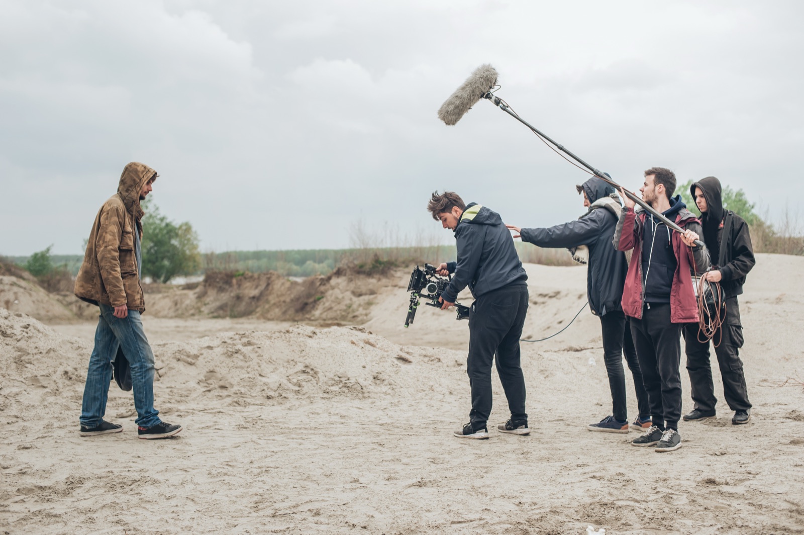 Outdoor filming vs studio production: video crew shooting on location with boom mic and camera rig